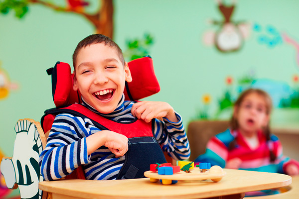 cheerful boy with disability at rehabilitation center for kids with special needs